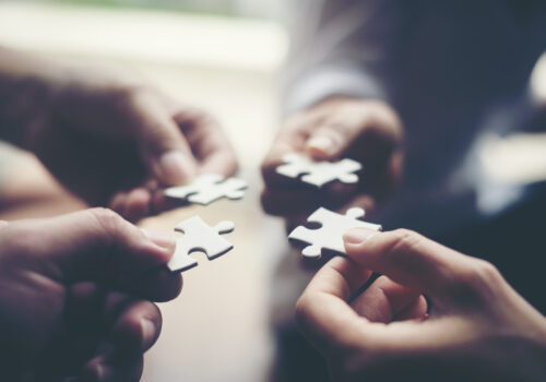 Hand holding jigsaw puzzles, Business partnership concept.